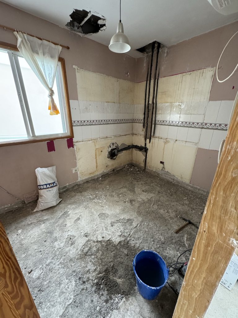 Estancia en obras con pavimento retirado y rozas para instalaciones en la pared