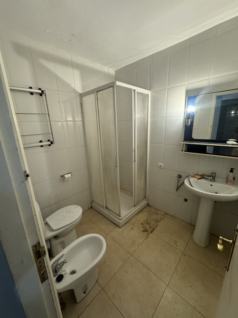Baño antes de reformar con cabina de ducha, lavabo de pedestal y bidé