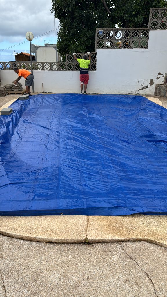 Piscina cubierta con lona azul mientras se renueva el cerramiento exterior