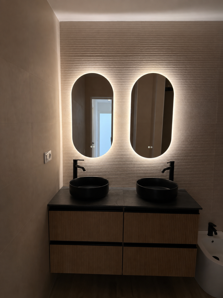 Baño con doble lavabo y dos espejos iluminados