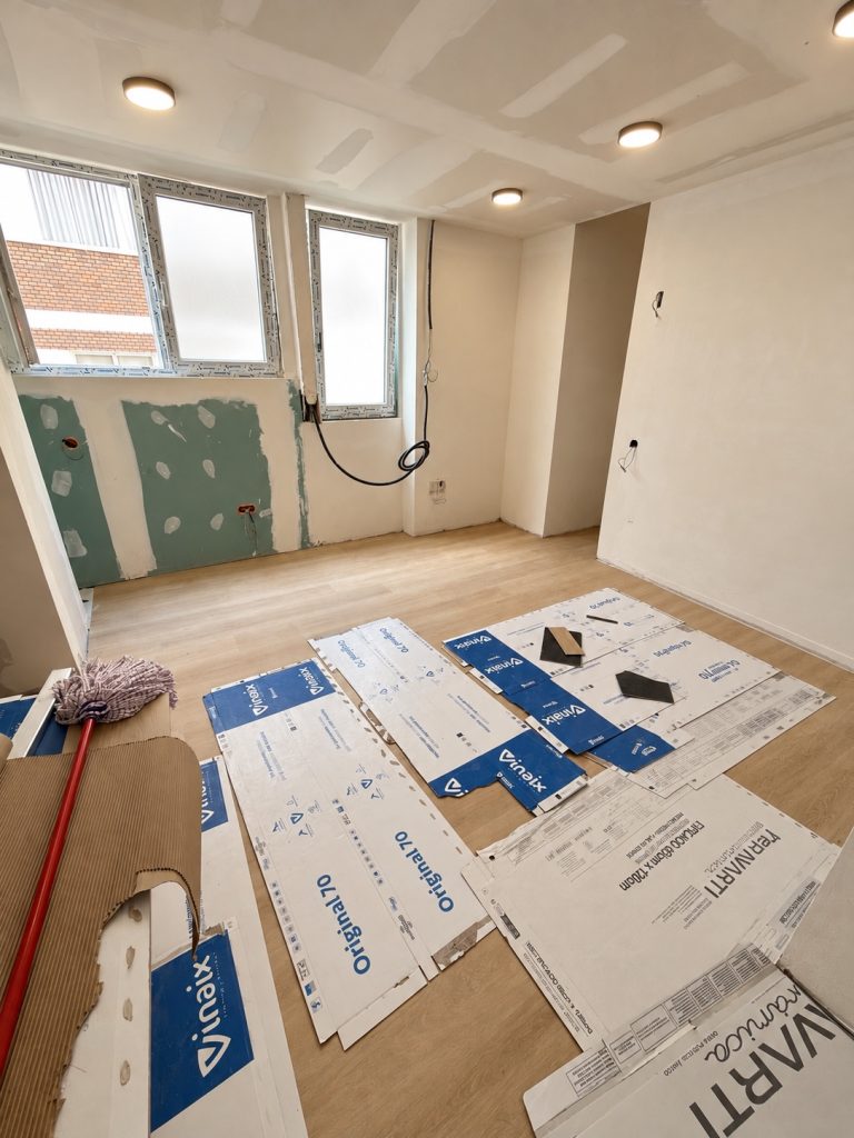 Baño en obras con ventana, paredes de placa e instalaciones preparadas
