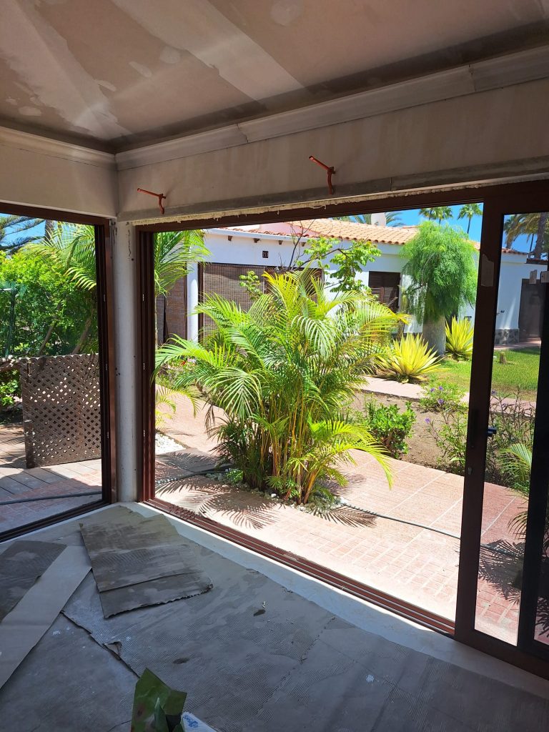 Terraza en obras con cerramiento acristalado y jardín exterior